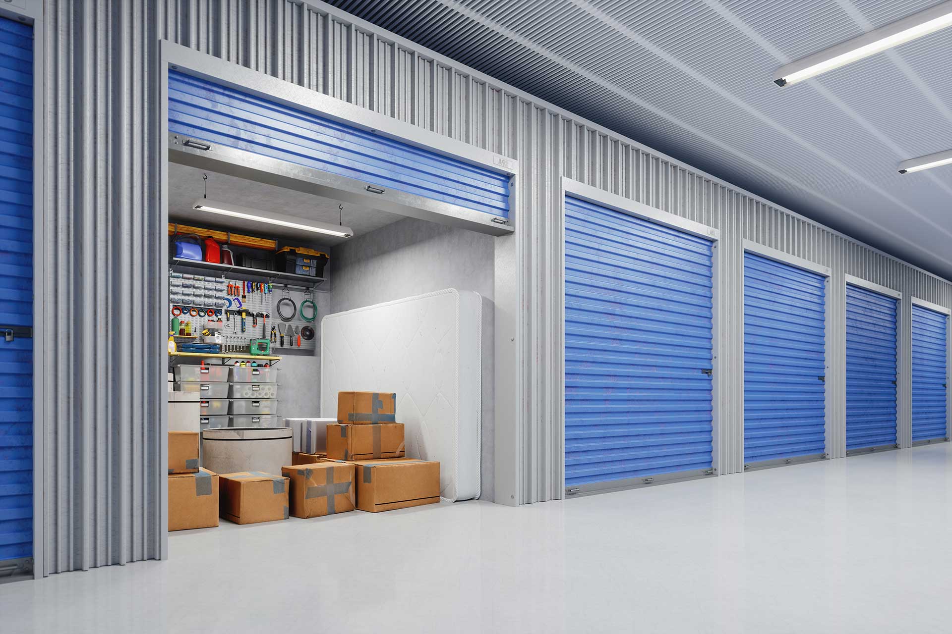 Storage units with blue doors, one is open showing boxes, a mattress, and other items. As the business owner of a self storage facility, you are subject to damage, theft, and liability that inherently come with owning or renting this type of space. Protecting your self-storage business, employees, monthly income, and legal rights is of essential importance.